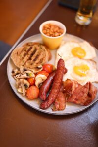 Anglická snídaně, vejce, klobása, slanina, rajčata, toast, fazole